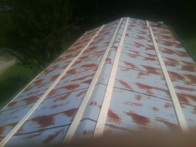 Rusted metal roof panels with new wood purlins before replacement — Storm Damage Roof Repair in Onley by Roofing Brothers